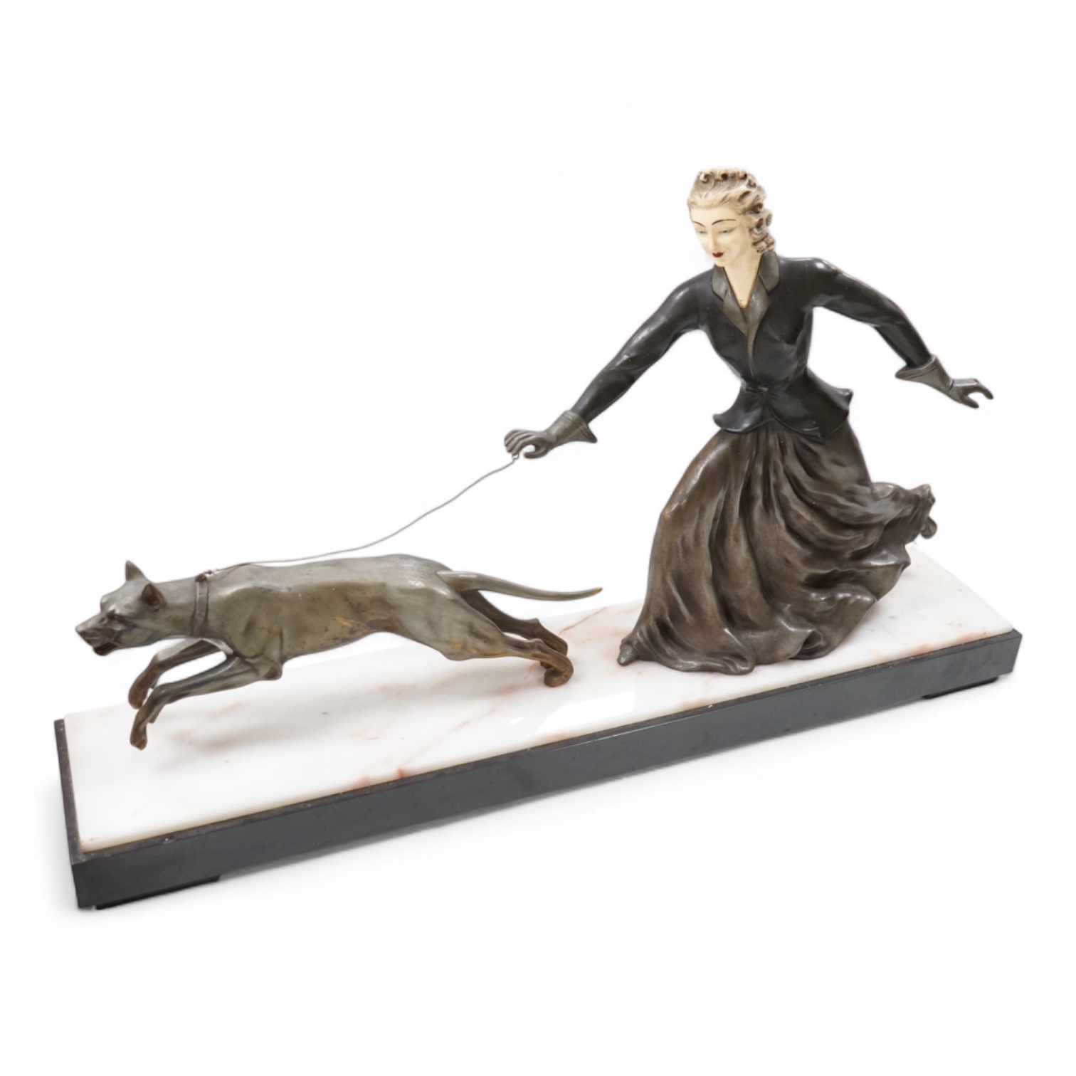 An Art Deco French spelter and ivorine model ‘Walkies Lady and Dog’, on a black marble and cream onyx base, 75cm long